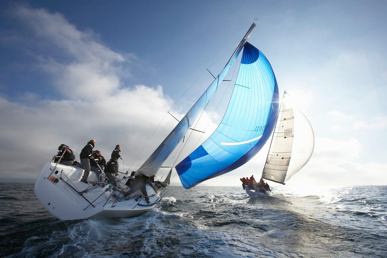 Racing yachts leaning hard into the wind under full sail